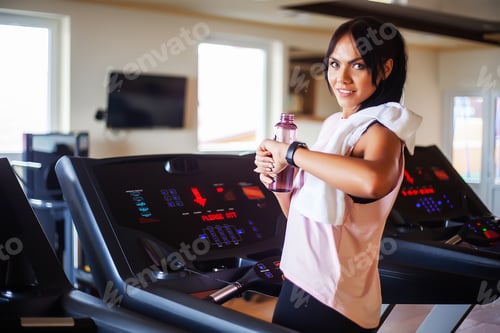 Preview: Young attractive woman doing exercises in fitness gym.