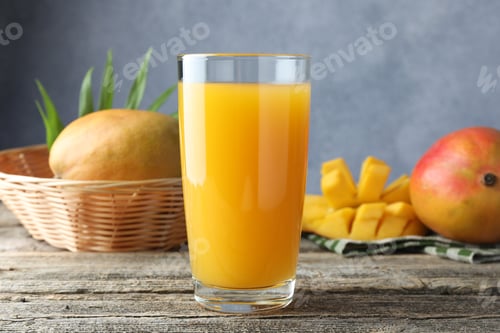 Vista previa: Tasty mango juice in glass and fresh fruits on wooden table