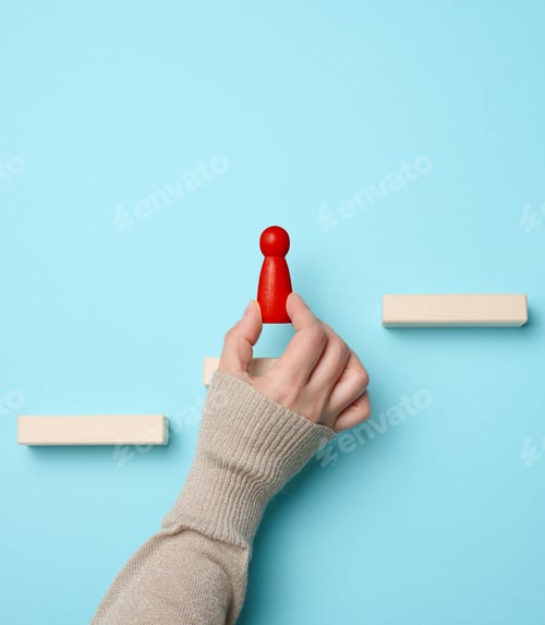 Preview: Wooden steps and a figurine of a little man in a woman's hand. Startup