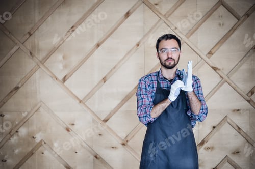 Preview: Portrait of a carpenter working in workshop wearing gloves