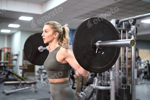 Preview: Caucasian woman training with barbells at the gym