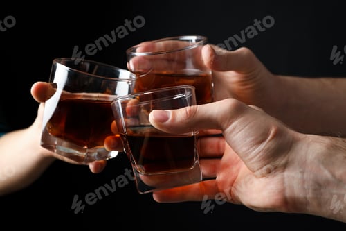 Preview: Three male hands holds glasses of whiskey on black background, close up. Cheers