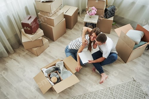 Preview: View from the top. Cheerful young couple in their new apartment. Conception of moving
