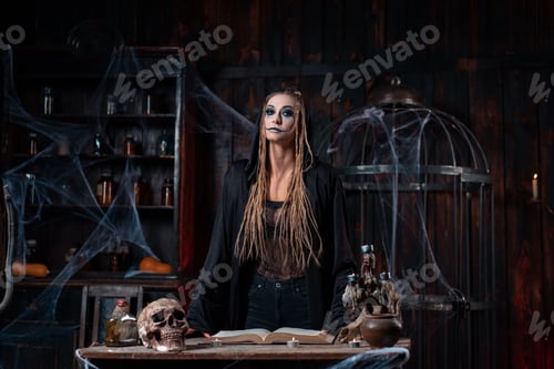 Preview: Halloween concept. Witch dressed black hood with dreadlocks standing dark dungeon room use magic boo