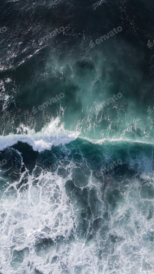 Preview: Vertical aerial shot of the waves on a deep blue sea