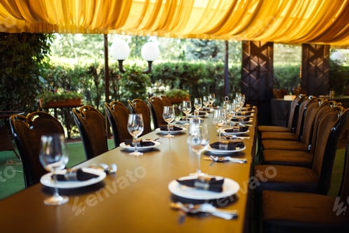 Preview: Sparkling glassware stands on long table prepared for wedding dinner.