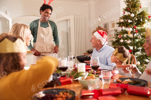 Preview: Father Serving Food At Multi-Generation Family Christmas Meal At Home