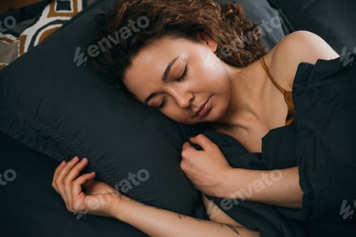 Preview: Relaxing sleep of young woman in cozy bed for calm morning