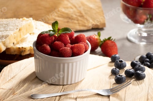 Preview: A wooden board with a bowl of delicious red raspberries