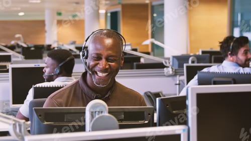 Preview: Mature Businessman Wearing Telephone Headset Working In Customer Services Department