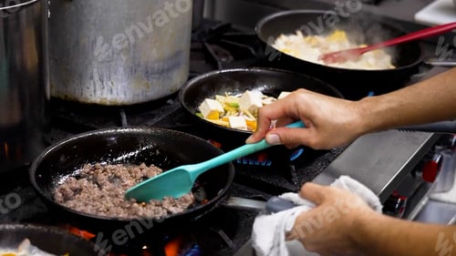 Preview: Person cooking and preparing traditional Thai cuisine in pans.