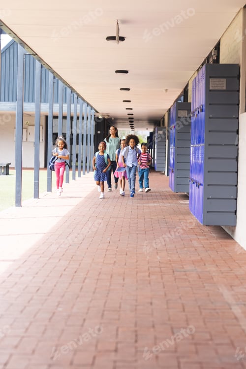 Preview: In school, a diverse group of students is walking down the hallway with copy space outdoors