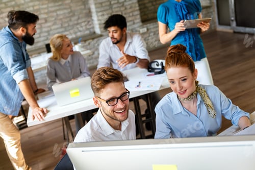 Preview: Smiling group of diverse businesspeople working together around a meeting table in an office