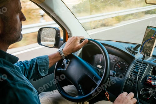 Preview: Close-up of hands on steering wheel inside van.