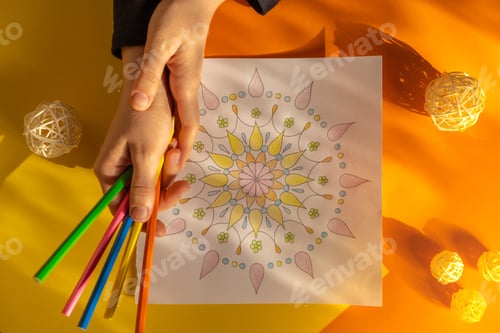 Preview: Woman coloring antistress page. Female hand painting mandala. Female painting mandalas to combat str