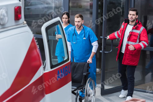 Preview: paramedics moving wheelchair from hospital to ambulance