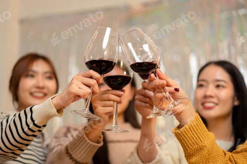 Preview: Beautiful woman smiling and clinking glass of wine to toasting with happiness while celebrating