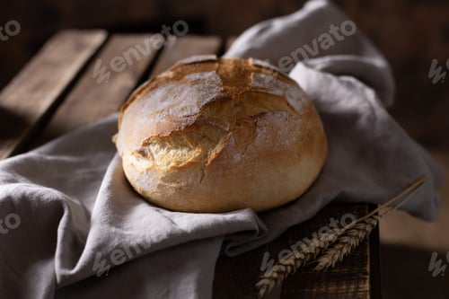 Preview: Bread and cloth napkin at table. Homemade bread on wooden tabletop as baking concept