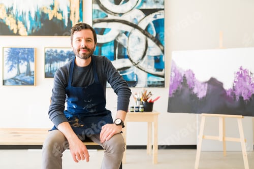 Preview: Portrait of a latin artist sitting next to his new artwork