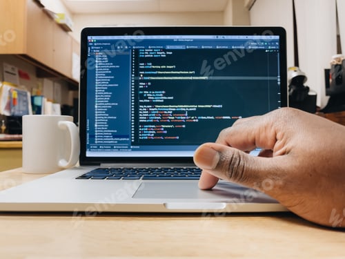 Preview: African American man using computer, computer code displayed on screen, programming, nerd culture