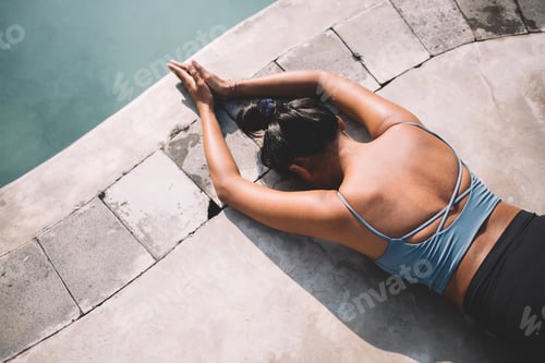 Preview: Woman Resting by the Turquoise Poolside in Sunlight