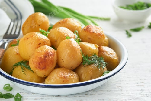 Preview: Boiled new or young potatoes with butter, fresh dill and onions in white bowl on white old rustic wo