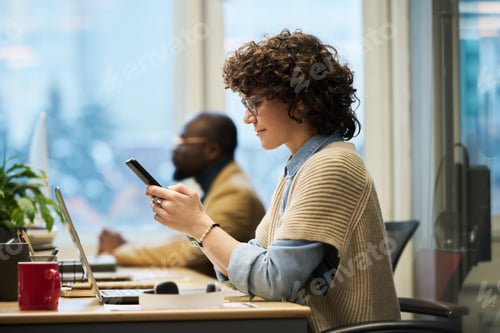 Preview: Side view of young brunette businesswoman with mobile phone