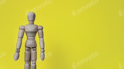 Preview: Close up image of wooden doll on yellow background