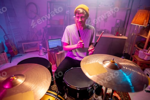 Preview: Young musician going to beat cymbals with drumsticks while making new music