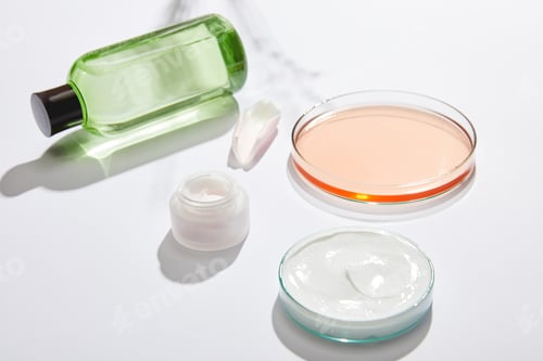 Preview: Cosmetic bottle with green liquid, jar with white cosmetic cream, laboratory glassware with liquid