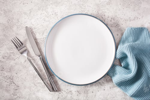 Preview: empty plate fork knife on concrete background
