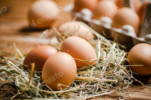 Preview: Chicken eggs on wooden table.