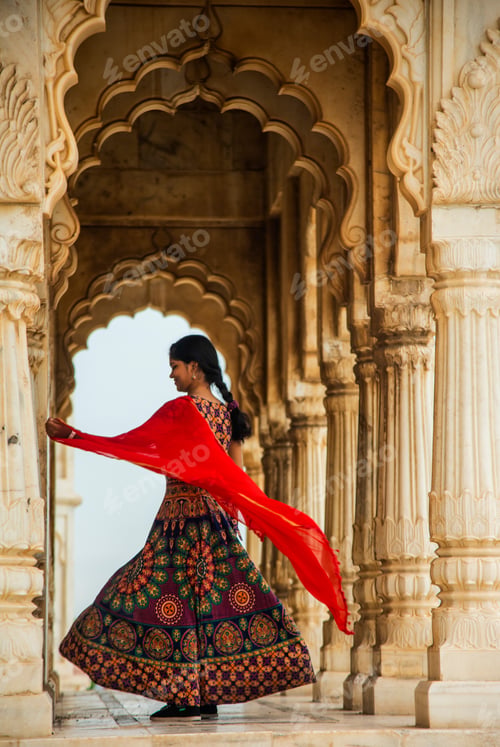 Preview: Young female tourist dancing between arches and Pillars.