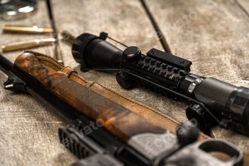 Preview: The optical sight and shotgun on wooden backgorund