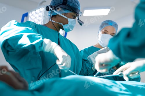 Preview: Diverse surgeons wearing surgical gowns operating on patient in operating theatre at hospital