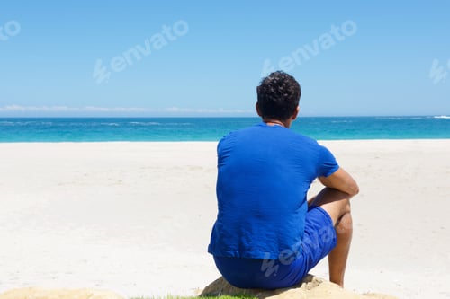 Preview: One man sitting alone at the beach