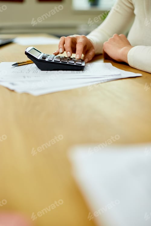 Preview: Woman hand using calculator for calculate domestic bills at home