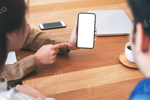 Preview: People using and looking at the same mockup mobile phone on wooden table together