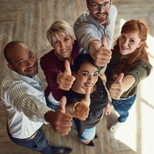 Preview: High angle portrait of a team of colleagues giving a thumbs up in a modern office