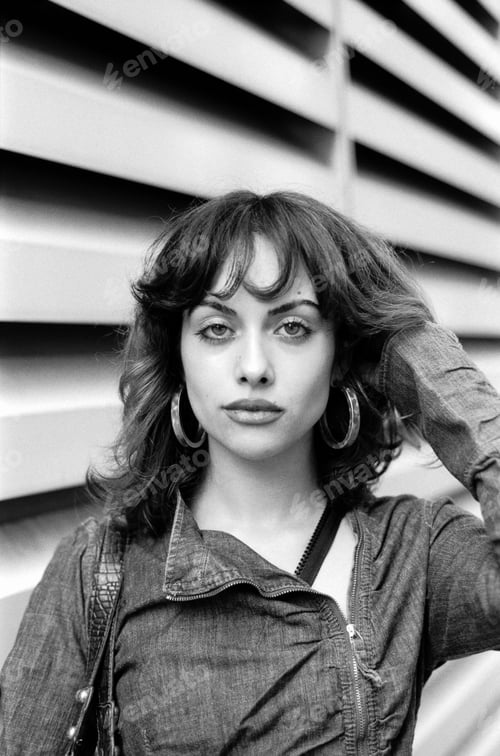 Preview: Fashion model posing in front of striped surface in monochrome portrait.