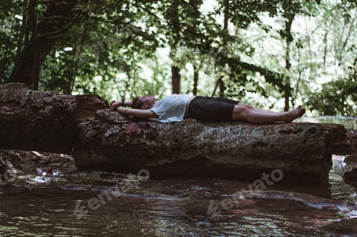 Preview: Woman relaxing on a fallen tree