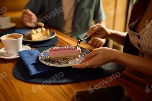 Preview: Close up of woman eating cake with her boyfriend in a cafe.