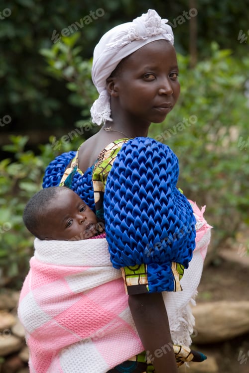 Preview: A mother carries her young child on her back, glancing at the camera with a serene expression.