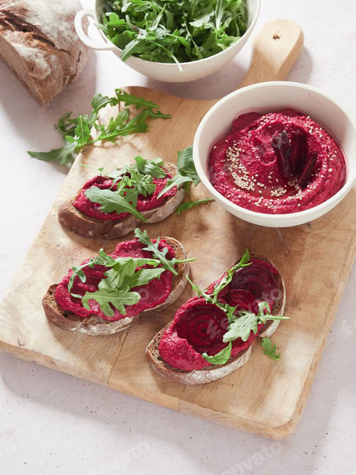 Preview: beet hummus in a bowl and served spread on slices of bread