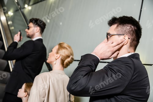 Preview: private security, professional bodyguards communicating while protecting safety of clients, rich