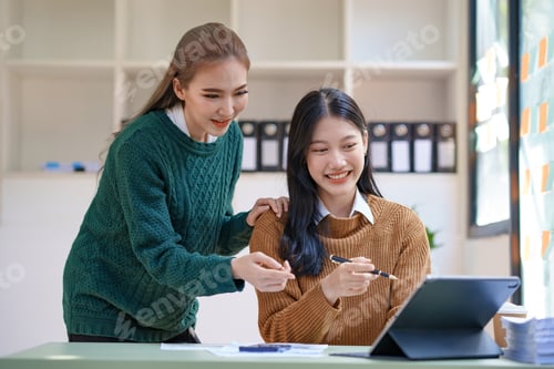 Preview: Two Asian businesswoman discussing market data graphs and company data charts, new investment