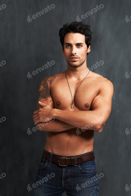 Preview: Confident and buff. A shirtless young man standing with his arms folded.