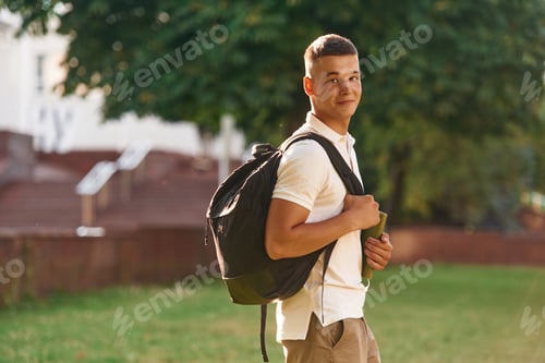 Preview: With backpack. Young male student is outdoors