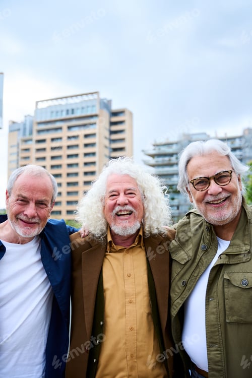 Preview: Portrait of joyful three only mature male Caucasian friends posing happy hugging together in city.
