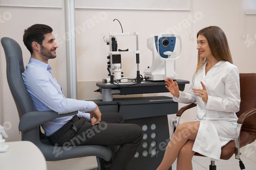 Preview: Ophthalmologist talking to male patient at the table
